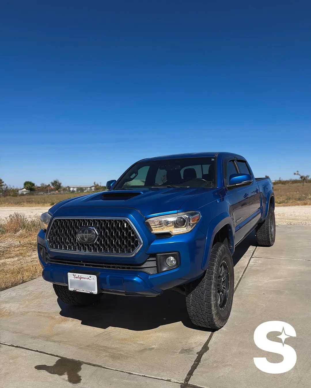 Blue Toyota Tacoma freshly detailed under a High Desert sky